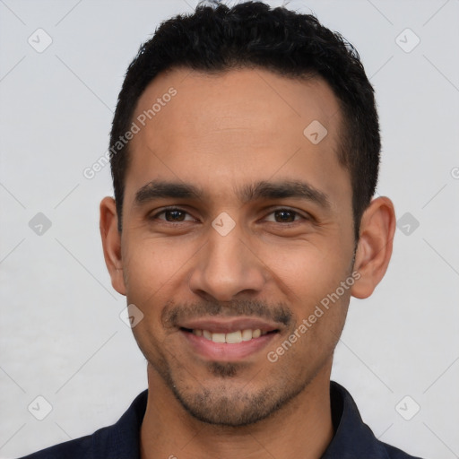 Joyful latino young-adult male with short  black hair and brown eyes