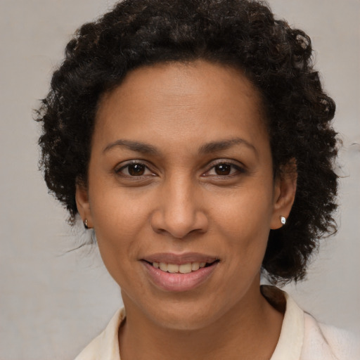 Joyful latino adult female with medium  brown hair and brown eyes