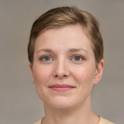 Joyful white young-adult female with short  brown hair and grey eyes