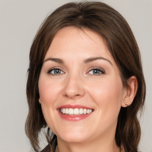 Joyful white young-adult female with medium  brown hair and green eyes