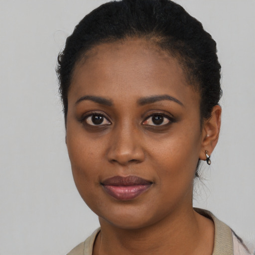 Joyful black young-adult female with short  black hair and brown eyes
