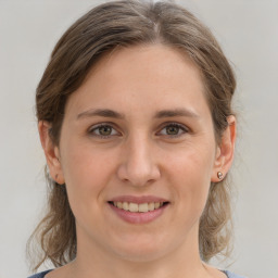 Joyful white young-adult female with medium  brown hair and grey eyes