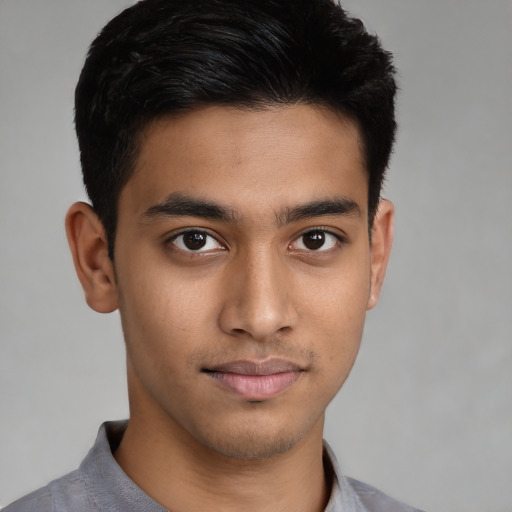 Joyful latino young-adult male with short  brown hair and brown eyes