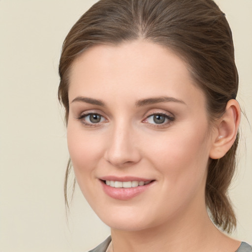 Joyful white young-adult female with medium  brown hair and green eyes