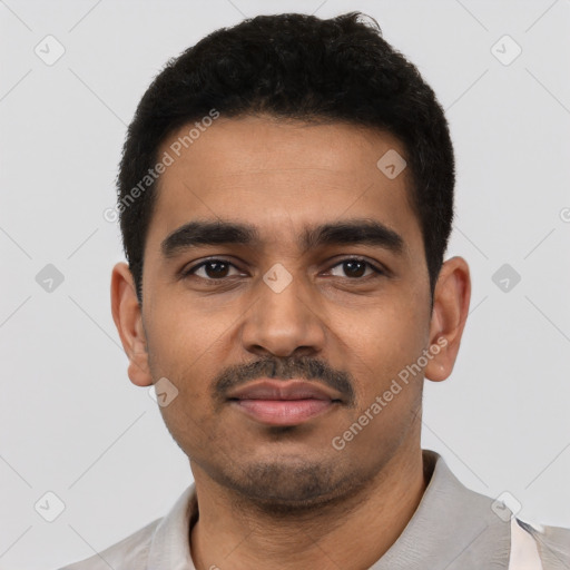 Joyful latino young-adult male with short  black hair and brown eyes