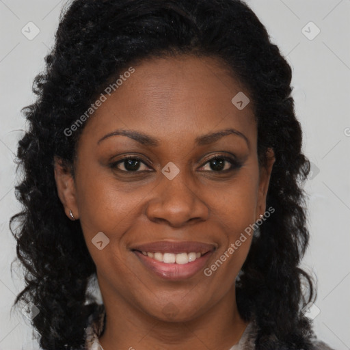Joyful black adult female with long  brown hair and brown eyes
