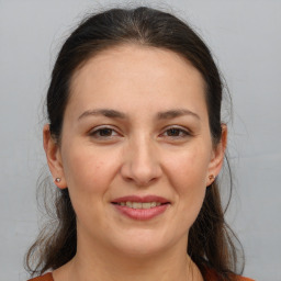 Joyful white adult female with medium  brown hair and brown eyes