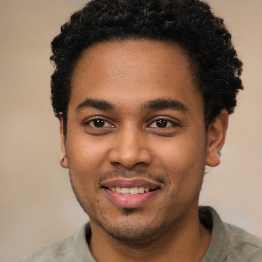 Joyful black young-adult male with short  black hair and brown eyes