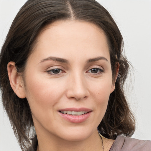 Joyful white young-adult female with medium  brown hair and grey eyes