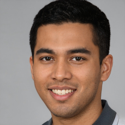 Joyful latino young-adult male with short  black hair and brown eyes