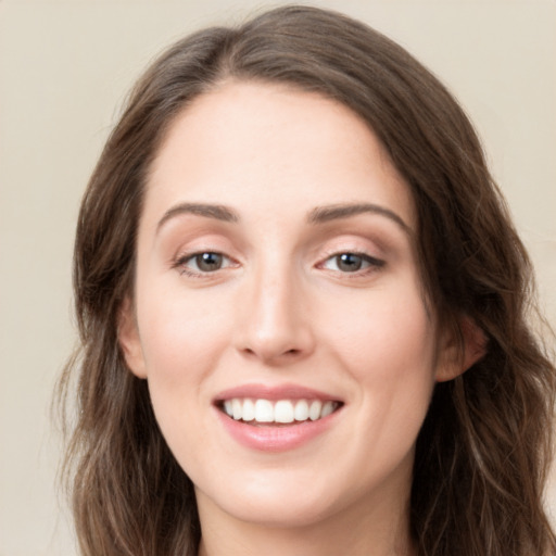 Joyful white young-adult female with long  brown hair and green eyes