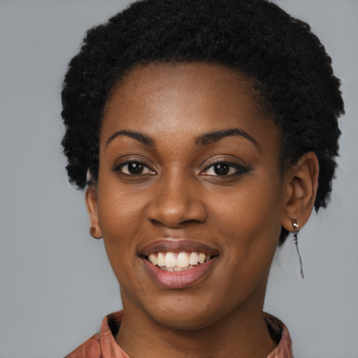 Joyful black young-adult female with long  black hair and brown eyes