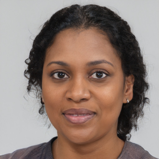 Joyful black young-adult female with medium  brown hair and brown eyes