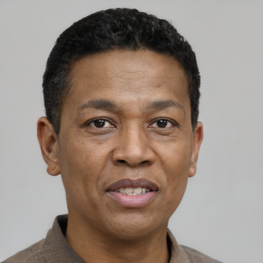 Joyful black adult male with short  brown hair and brown eyes