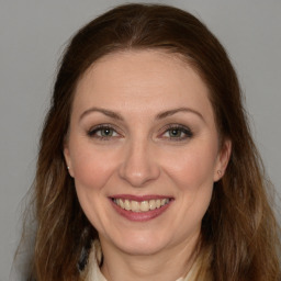 Joyful white adult female with medium  brown hair and brown eyes