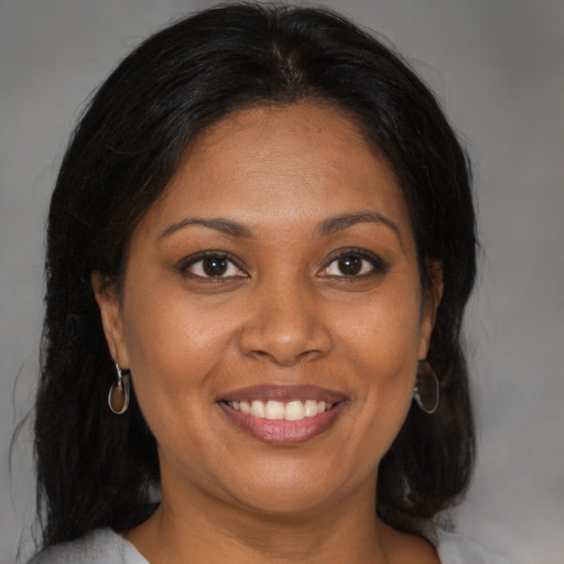 Joyful black adult female with medium  brown hair and brown eyes