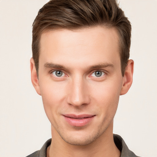 Joyful white young-adult male with short  brown hair and grey eyes