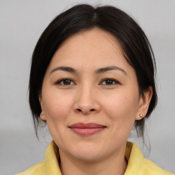 Joyful asian adult female with medium  brown hair and brown eyes