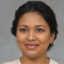 Joyful black adult female with medium  brown hair and brown eyes