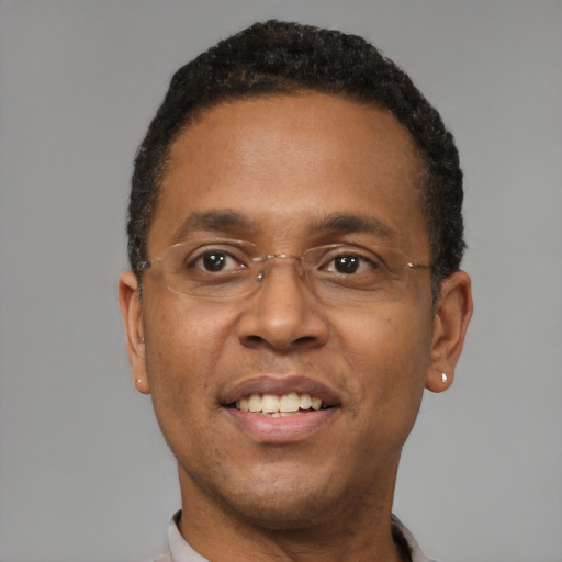 Joyful black adult male with short  black hair and brown eyes