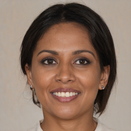 Joyful black young-adult female with medium  brown hair and brown eyes