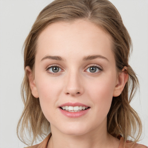 Joyful white young-adult female with medium  brown hair and blue eyes