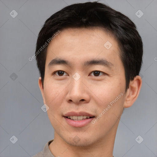 Joyful asian young-adult male with short  brown hair and brown eyes