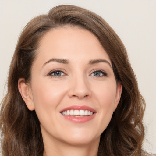 Joyful white young-adult female with long  brown hair and grey eyes