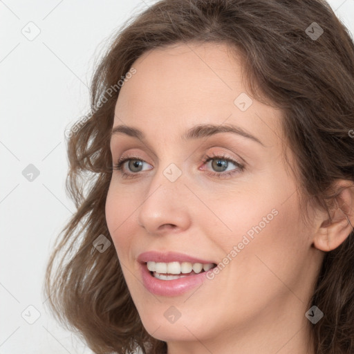 Joyful white young-adult female with long  brown hair and grey eyes