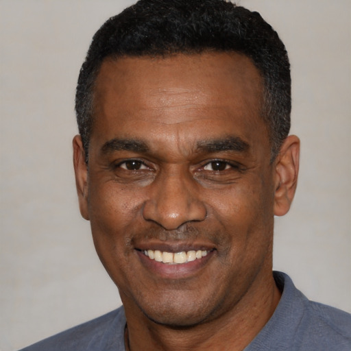 Joyful black adult male with short  black hair and brown eyes