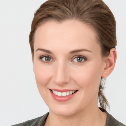 Joyful white young-adult female with medium  brown hair and grey eyes