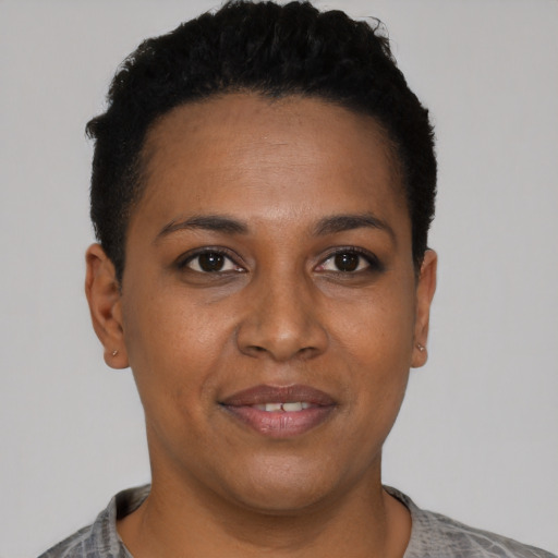 Joyful black young-adult female with short  black hair and brown eyes
