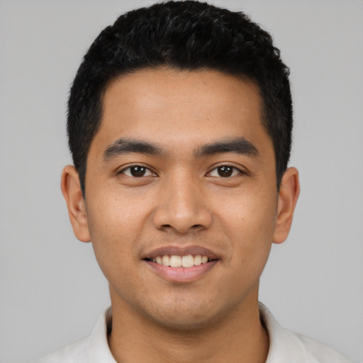 Joyful latino young-adult male with short  black hair and brown eyes