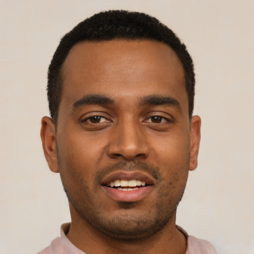Joyful black young-adult male with short  black hair and brown eyes