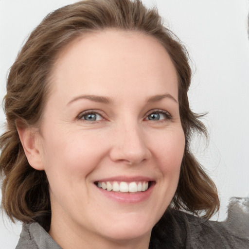 Joyful white young-adult female with medium  brown hair and blue eyes