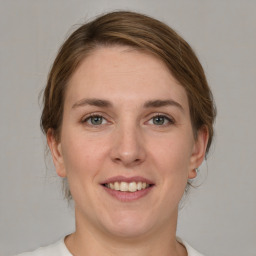 Joyful white young-adult female with medium  brown hair and green eyes