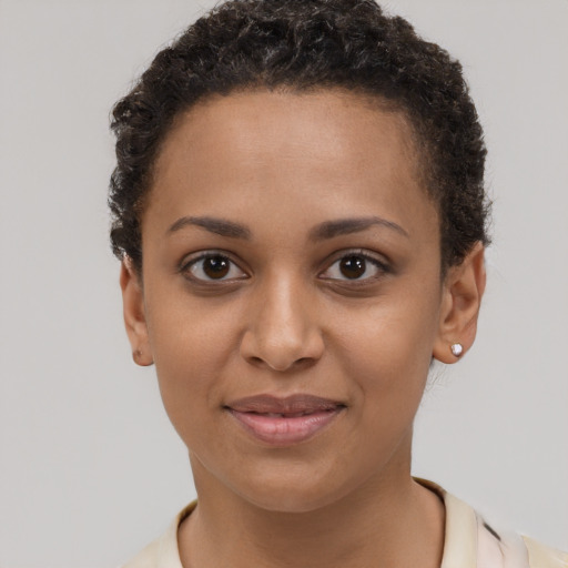 Joyful black young-adult female with short  brown hair and brown eyes
