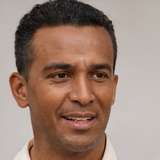 Joyful latino adult male with short  brown hair and brown eyes