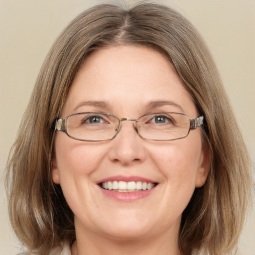 Joyful white adult female with medium  brown hair and green eyes