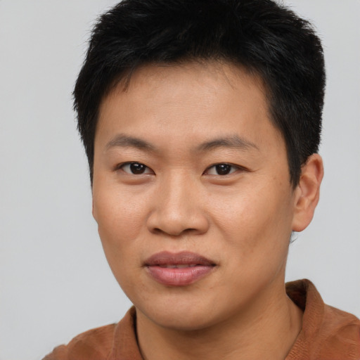 Joyful asian young-adult male with short  brown hair and brown eyes