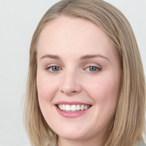 Joyful white young-adult female with long  brown hair and blue eyes