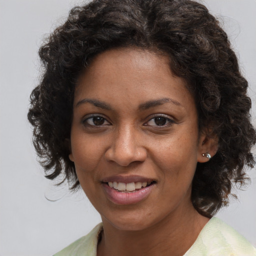 Joyful black young-adult female with medium  brown hair and brown eyes