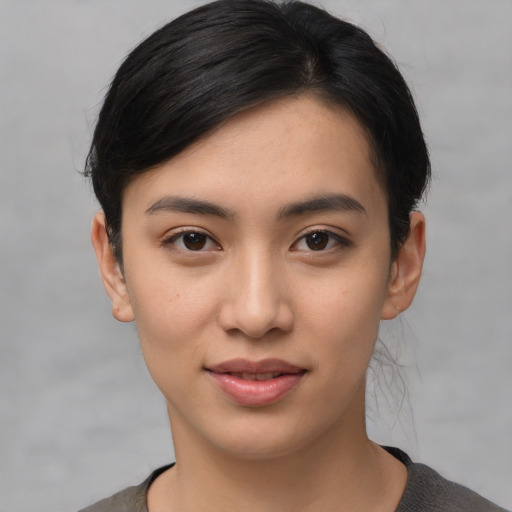 Joyful asian young-adult female with short  black hair and brown eyes