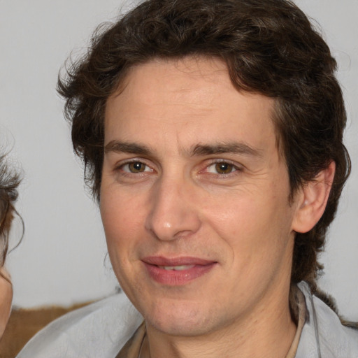 Joyful white adult male with medium  brown hair and brown eyes