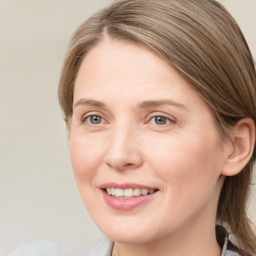 Joyful white young-adult female with medium  brown hair and blue eyes