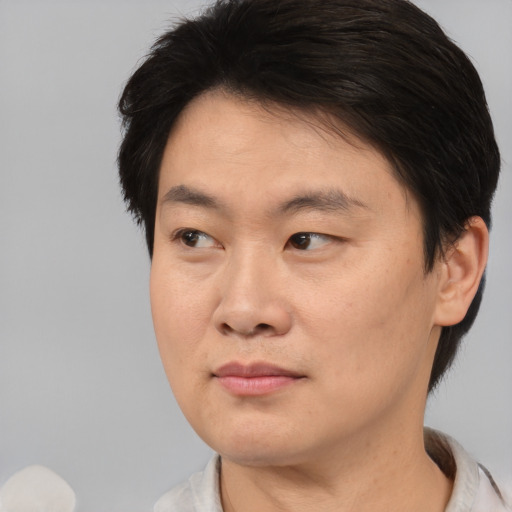 Joyful asian adult male with medium  brown hair and brown eyes