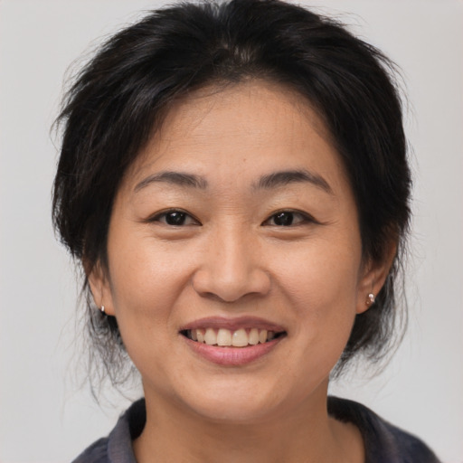Joyful asian adult female with medium  brown hair and brown eyes