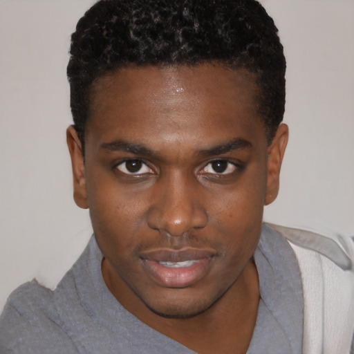 Joyful black young-adult male with short  brown hair and brown eyes