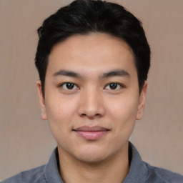 Joyful asian young-adult male with short  black hair and brown eyes