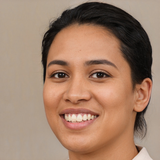 Joyful latino young-adult female with long  black hair and brown eyes